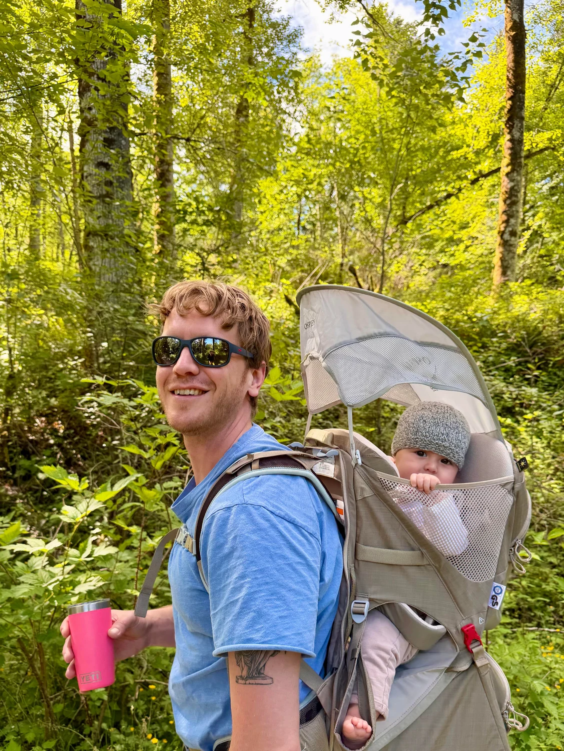 Ryan Peterson carrying his child on a walk in the woods.
